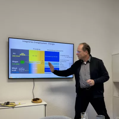 Thorsten Breitschuh steht vor einem Bildschirm und erklärt die Energiewende im Südlichen Anhalt