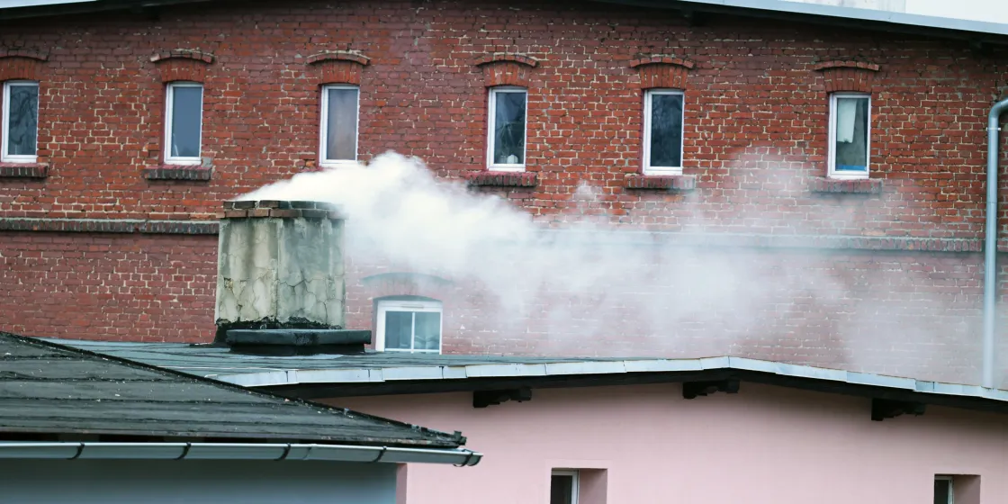 Giftiger Rauch kommt aus dem Schornstein eines Wohnhauses