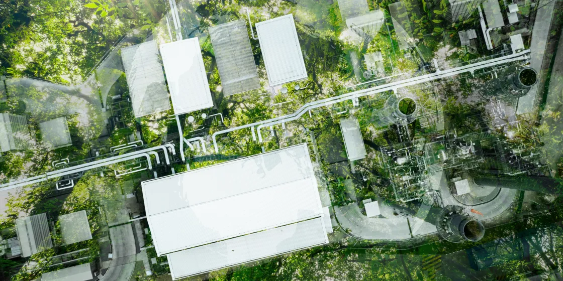 Aerial view of a factory among green trees and bushes