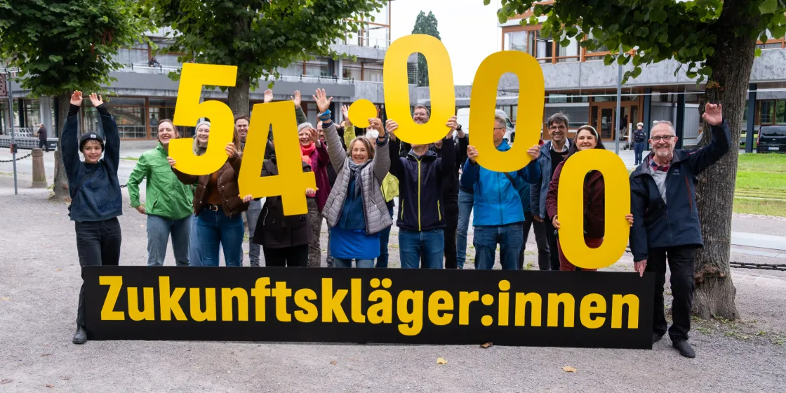 Zukunftskläger:innen halten gelbe Ziffern "5.400" in die Höhe