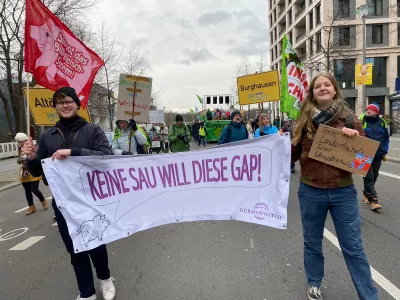 Zwei Menschen zeigen ein Banner auf einer Demonstration
