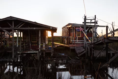 Fig. 4. Impacts of sea level rise in the US: Abandoned, flooded, and ruined homes along the only road traversing isle de jean Charles, in the Terrebonne area of Luisiana (Juan Diego Reyes / Climate Visuals).