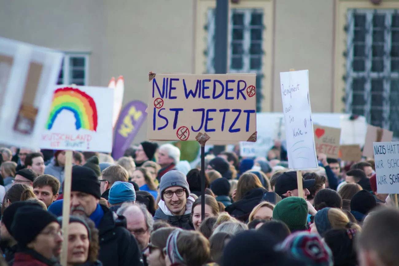 Demonstrierende mit Schild "Nie wieder ist Jetzt"