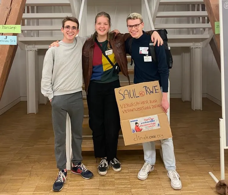 Drei Freiwillige stehen in einem Seminarraum