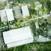 Aerial view of a factory among green trees and bushes