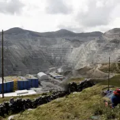 Indigenous person overlooks huge copper mine in the Andes